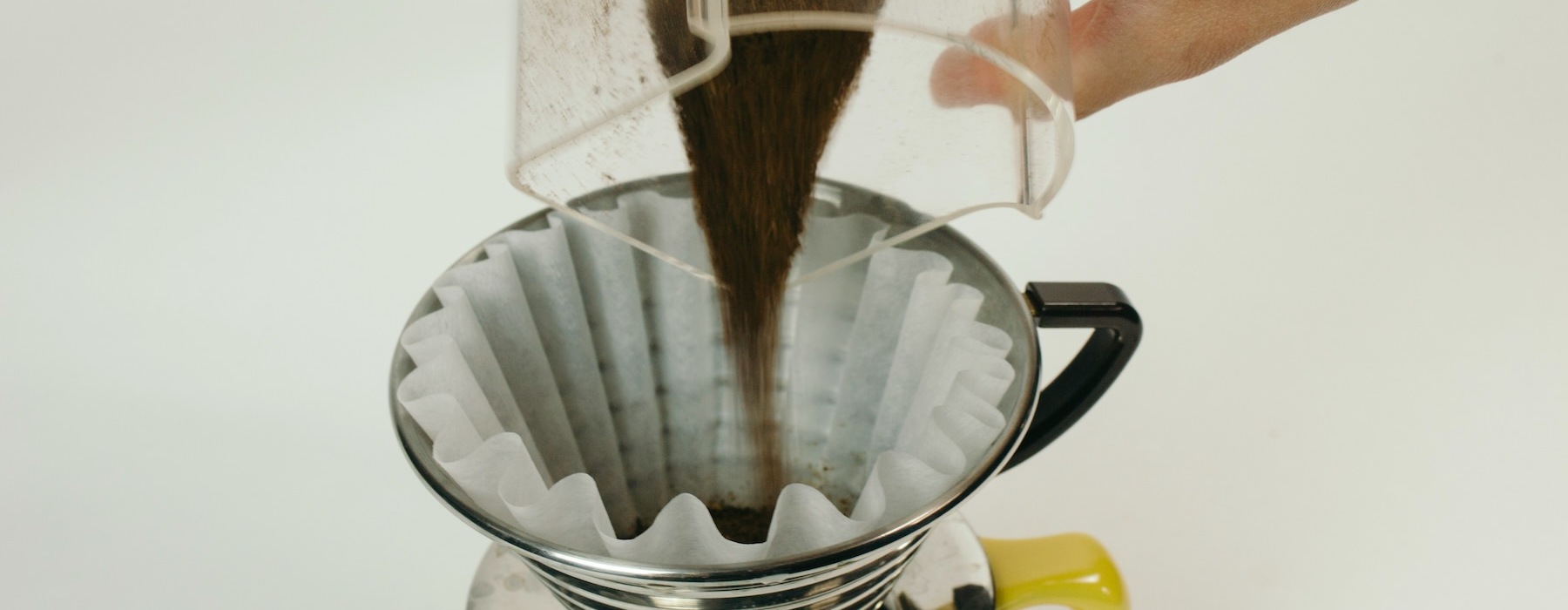 a person pouring coffee grounds