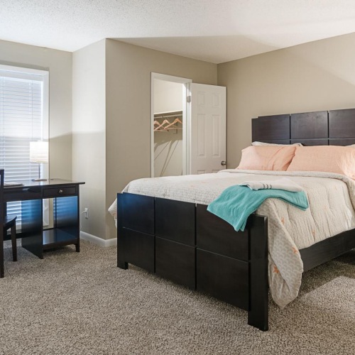 a bedroom with a bed, desk and a chair